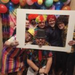 5 osób w przebraniach karnawałowych trzyma ramkę do zdjęć.